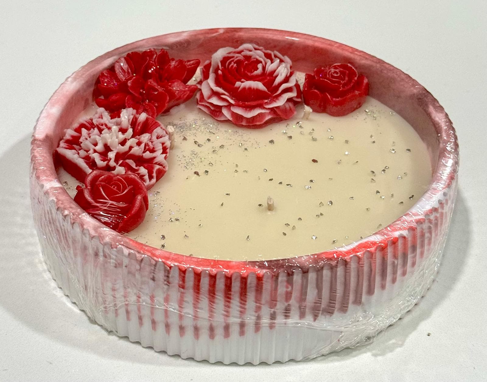 Vela decorativa artesanal con flores rojas