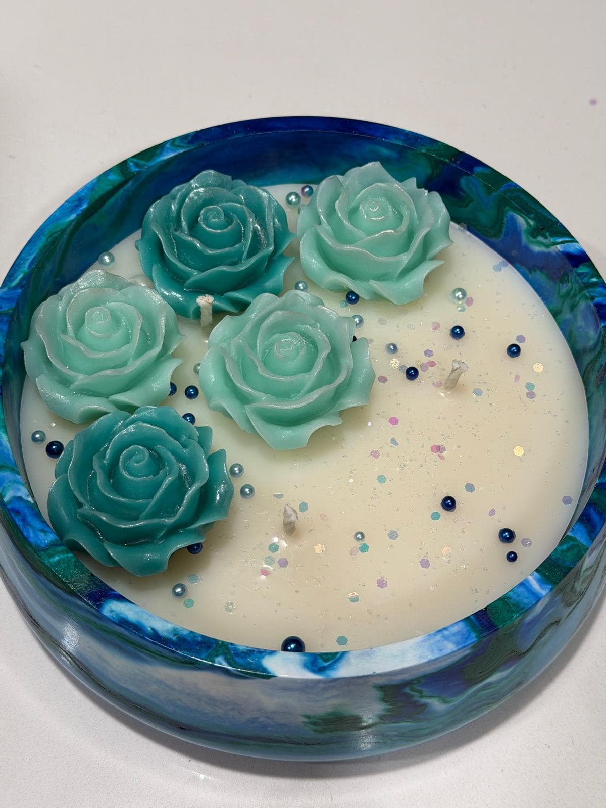 Vela decorativa en recipiente circular con rosas