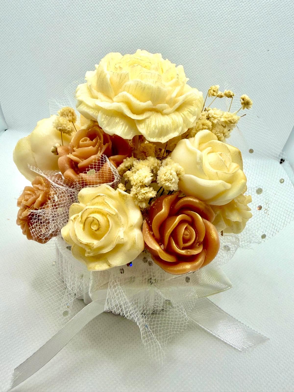 Arreglo floral decorativo de velas de cera en tonos marfil y dorado
